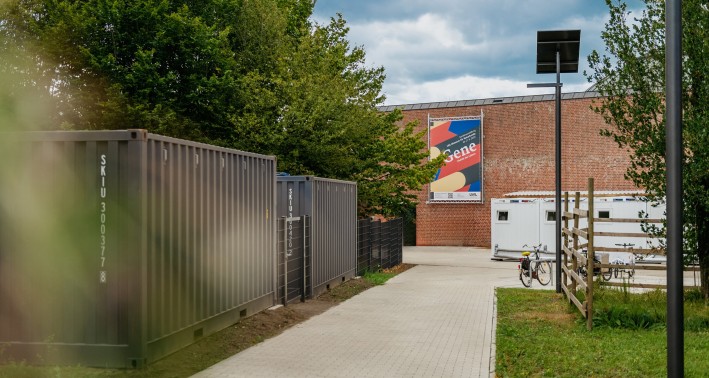 Museumsgebäude mit umgebenden Grünanlagen, 2 Containern und einem WC-Container auf dem Vorplatz.