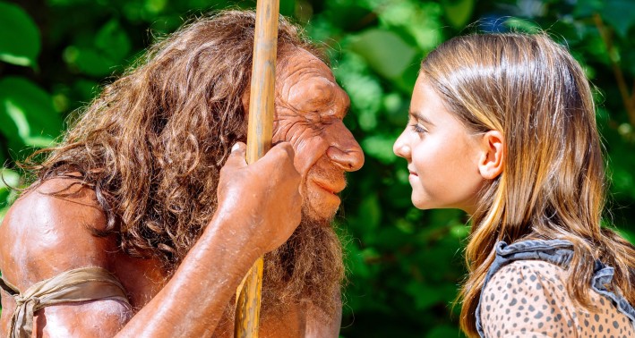 Figur des Neanderthalers mit einem Kind aus der Gegenwart