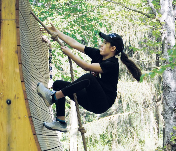 Kind, das an einer Steilen Wand an einem Seil klettert