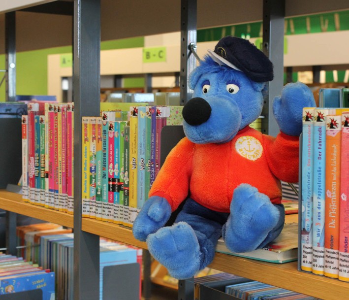 Foto: Stadtbibliothek Mülheim an der Ruhr Das Bild zeigt ein Stofftier (von Käpt'n Blaubär) zwischen Kinderbüchern