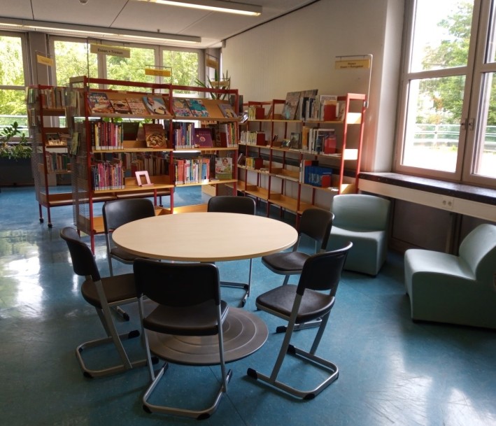 Blick in die Bibliothek mit Sitzecke und Bücherregal