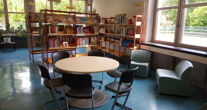 Blick in die Bibliothek mit Sitzecke und Bücherregal