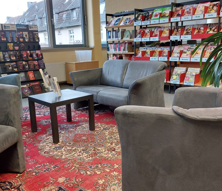 Das Foto zeigt einen Leseberecih der Stadtteilbibliothek mitBücherregalen und Sofa.