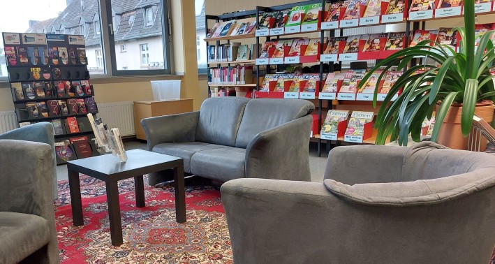 Das Foto zeigt einen Leseberecih der Stadtteilbibliothek mitBücherregalen und Sofa.