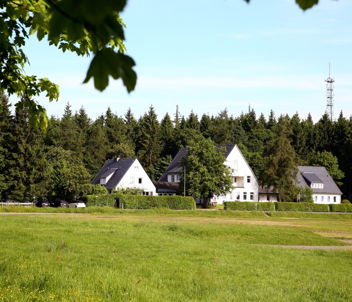 Foto: Wald und Holz NRW Das Bild zeigt eine Gruppe von Häusern vor einem Waldstück