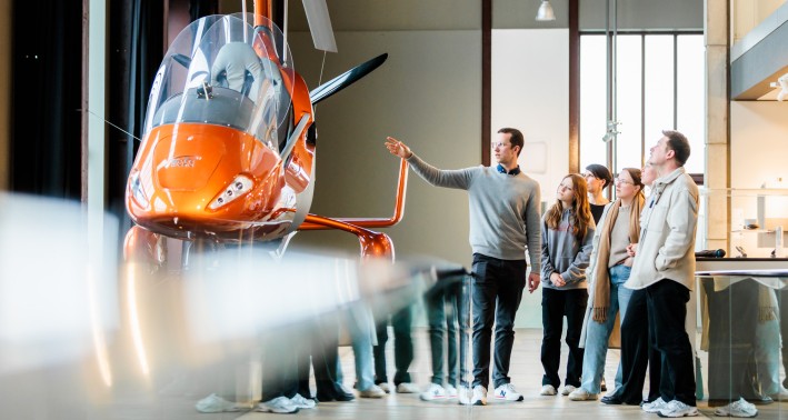 Menschen vor einem Ausstellungsobjekt während einer Führung