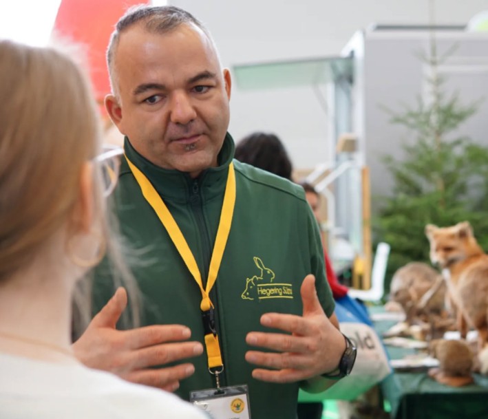 Im Vordergrund befindet sich Herr Peter Gabriel Müller, Obmann Rollende Waldschule der Kreisjägerschaft. Im Hintergrund sind einzelne Tierpräparate zu erkennen. 