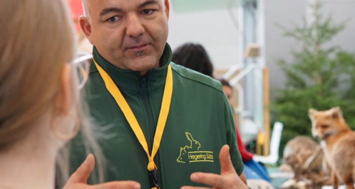 Im Vordergrund befindet sich Herr Peter Gabriel Müller, Obmann Rollende Waldschule der Kreisjägerschaft. Im Hintergrund sind einzelne Tierpräparate zu erkennen.