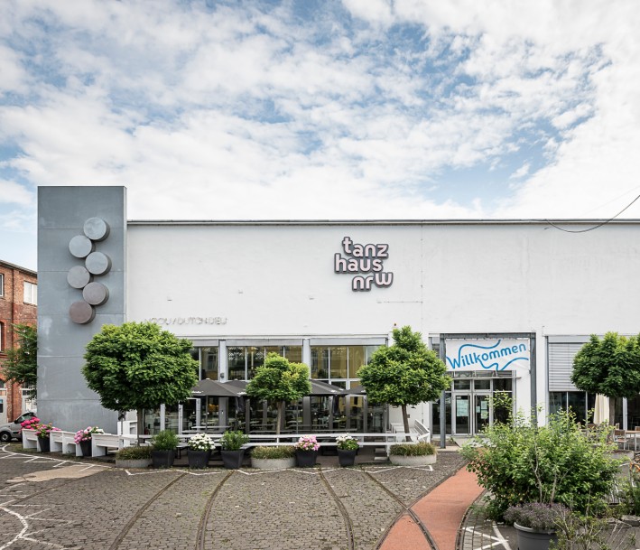 modernisiertes Straßenbahndepot mit großer Fensterfront, Begrünung vor dem Gebäude