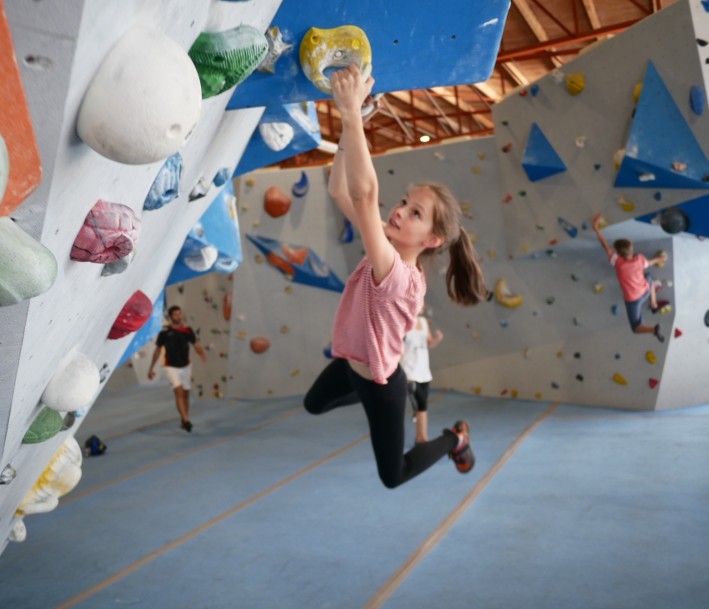 Foto: Kletteraixperten GmbH Aufnahme in einer Kletterhalle, junges Mädchen klettert