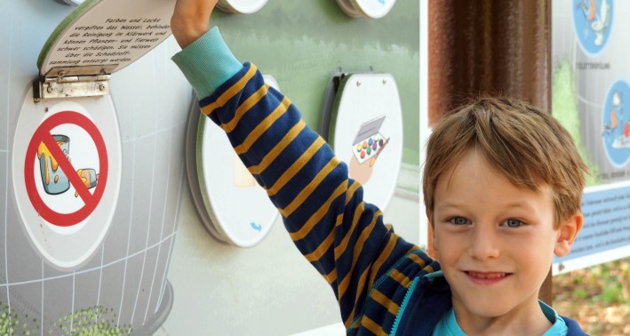 Ein Kind, das Lernkarten am Klärwerk des Lernorts Wasserschule in Köln in der Hand hält.