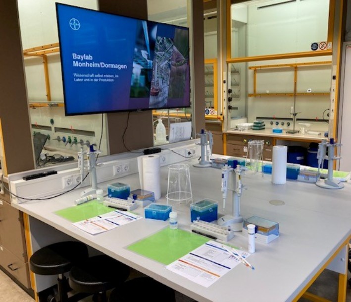 Das Bild zeigt einen Ausschnit des Baylab Schülerlabor Monheim. Zu sehen sind ein exemplarischer Arbeitstisch mit vielen technischen Geräten wie Mikroskopen und ähnlichem.