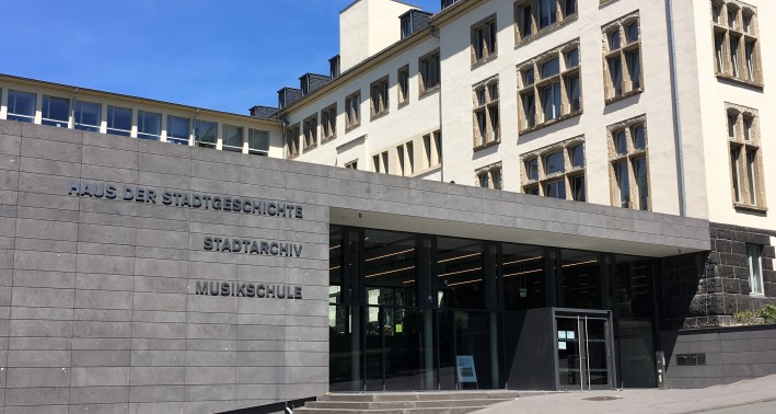 EIn moderner dunkler Bau mit der Aufschrift 'Haus der Stadtgeschichte. Stadtarchiv. Musikschule.'