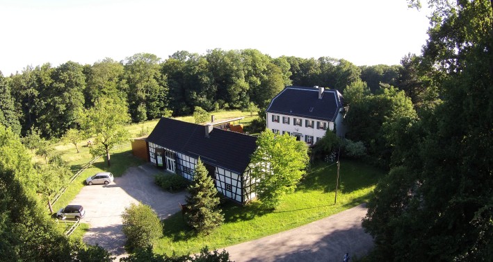 Waldinformationszentrum Steinhaus umgeben von Wiesen und Bäumen 