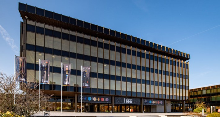 Das Gebäude des Heinz-Nixdorf-Forums mit Flaggen in der Sonne