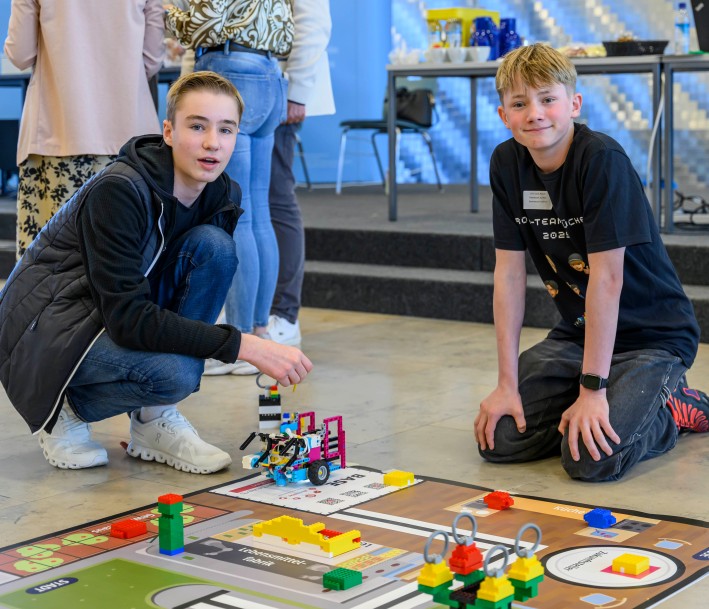 Foto: Wolfgang Walter Das Bild zeigt zwei Schüler, die aus Bausteine Roboter bauen und diese jetzt auf einer Matte austesten
