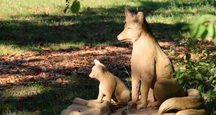 Aus Holz geschnitzte Füchs als Themenstation am Megalithgrab Atteln in Lichtenau. 