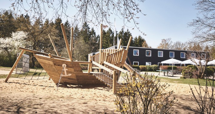 Spielplatz mit einem Holzboot der Jugendherberge Biggesee.
