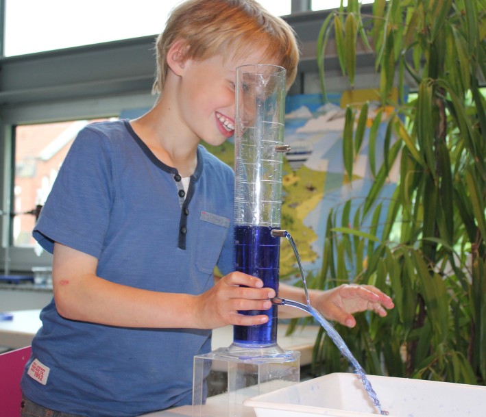 Ein Schüler experimentiert mit Wasser im Wasserwerk Westhoven am Lernort der Wasserschule.