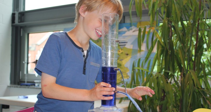 Ein Schüler experimentiert mit Wasser im Wasserwerk Westhoven am Lernort der Wasserschule.