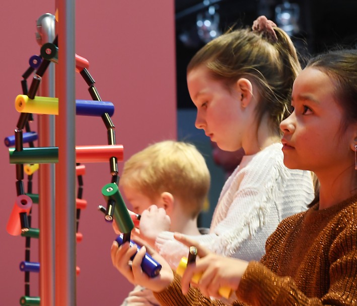 Drei Kinder betrachten ein Ausstellungsstück des Discovery Museums