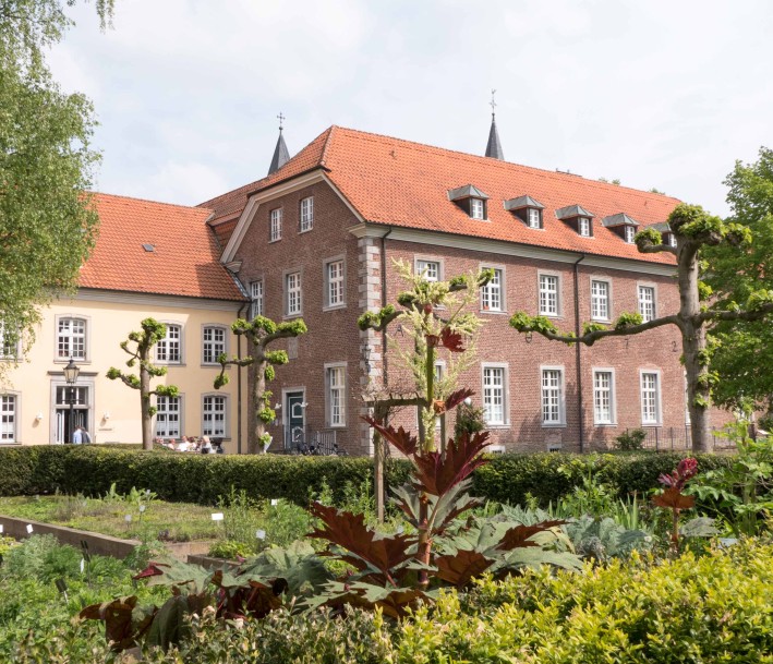 Blick auf das Kloster Saarn mit Kräutergarten im Vordergrund