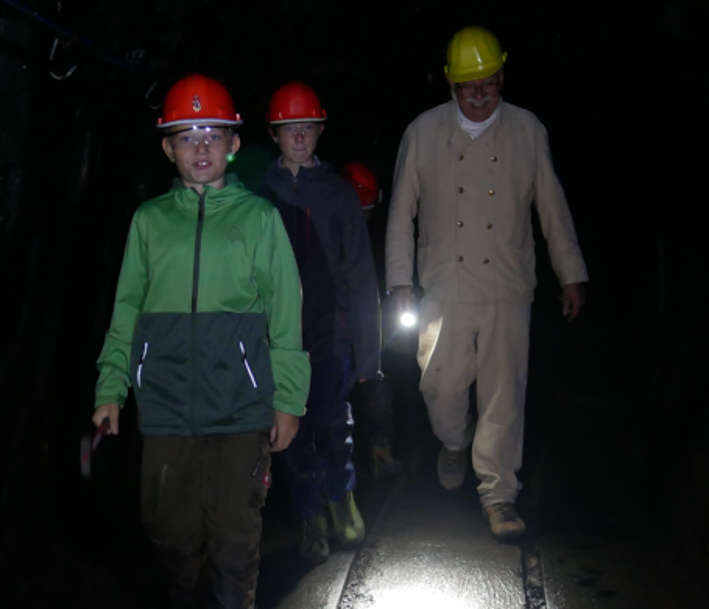 Eine Schüler'innengruppe durchquert den Lernort Besucherbergwerk Kilianstollen