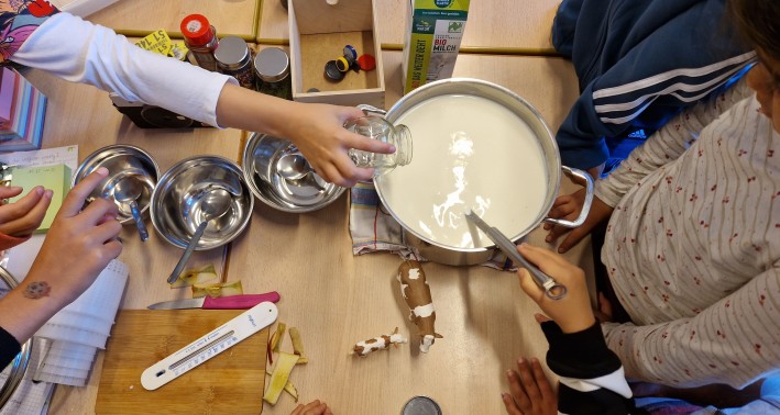 Kinder, die in einem Topf rühren