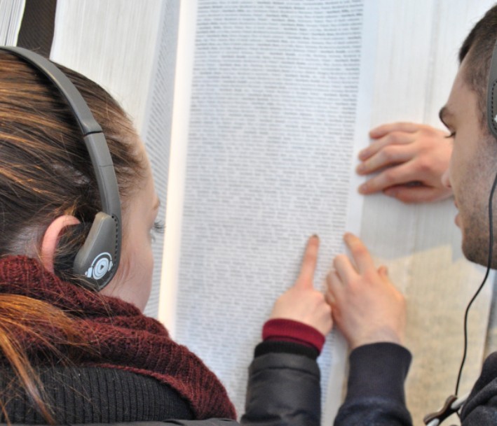Zwei junge Menschen recherchieren Namen in der Gedenkstätte Auschwitz