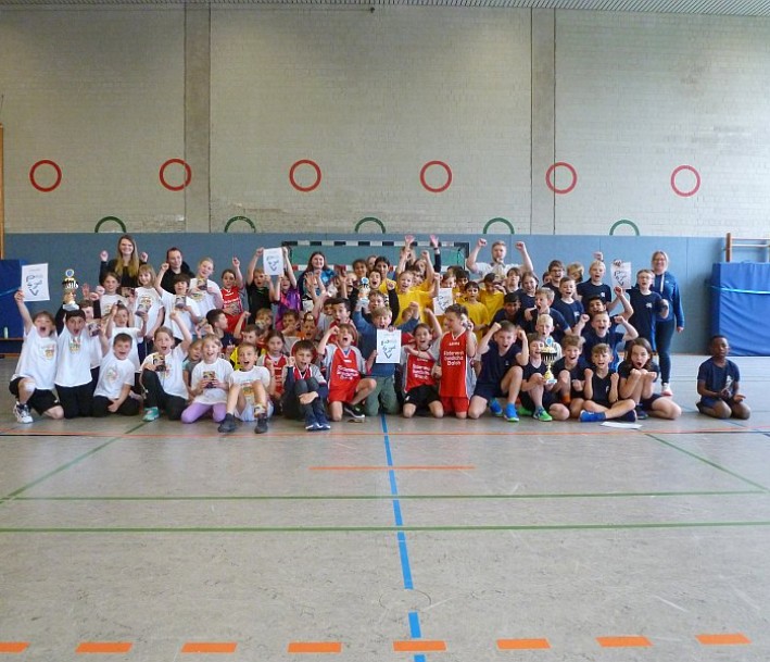 Das Foto zeigt eine Gruppe Schüler*innen in einer Sporthalle.