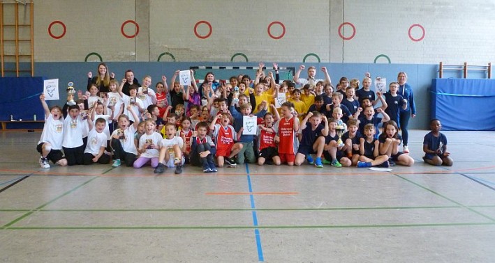 Das Foto zeigt eine Gruppe Schüler*innen in einer Sporthalle.