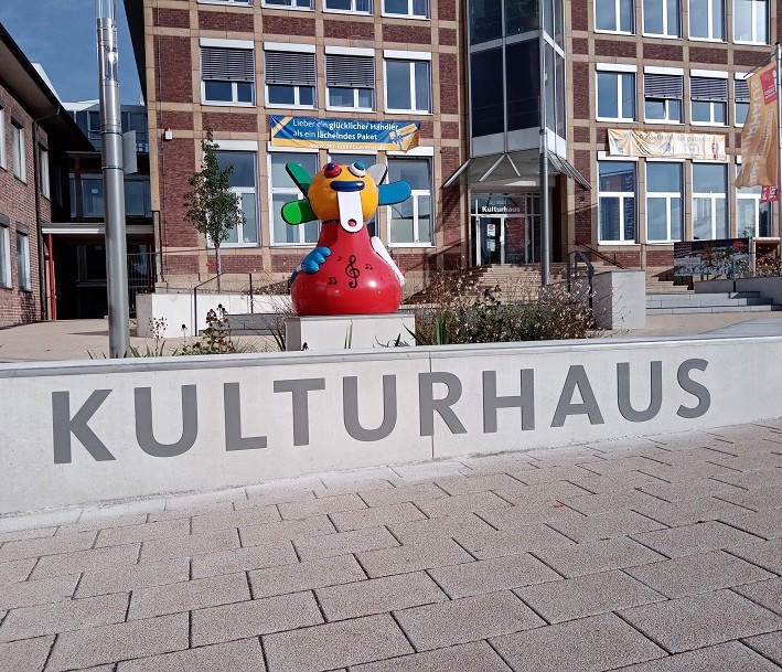Das Foto zeigt eine Kunstfigur über dem Schriftzug 
